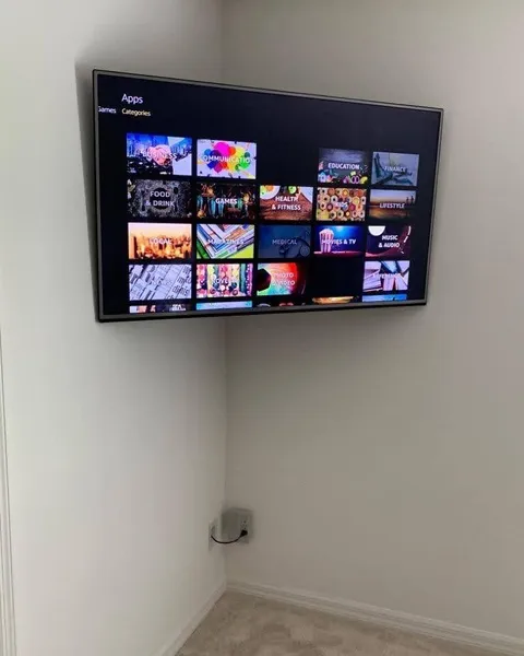 Corner-mounted TV with an internal power bridge for hidden wires
