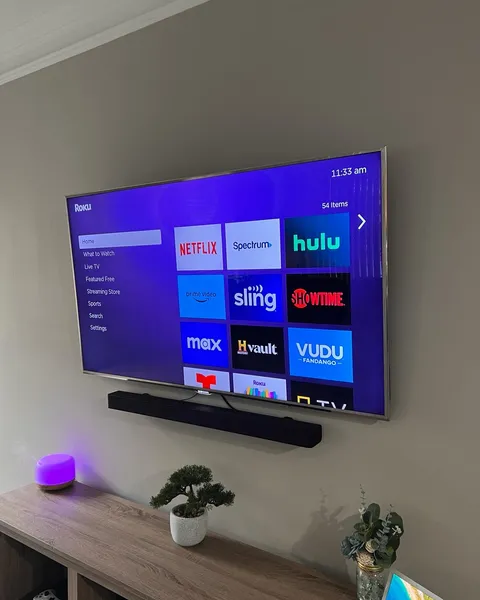 TV installed on a tilt mount with a soundbar and power bridge cable management
