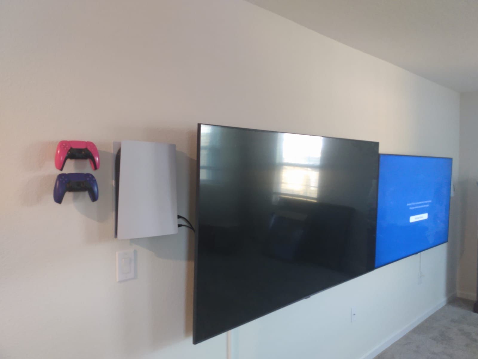 Multi TV install next to each other with a game console and 2 controller